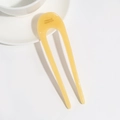 Detail of yellow U-shaped acetate hair pin with France Handmade text on white background - Yellow