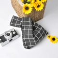 Detailed close-up of a black and white checkered linen wrist bag with a knot handle - Black Grid