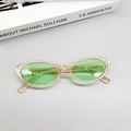 Close-up of vintage oval sunglasses showing transparent yellow frame and green lenses - Green