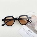 Kleine Retro-Sonnenbrille mit schwarzem Rahmen und bernsteinfarbenen Gläsern auf Weiß - Dunkelbraun