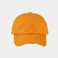 Close-up of orange washed cotton baseball cap featuring distressed holes and embroidery - Yellow