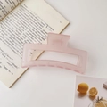 Macro detail of large matte pink square hair claw clip placed on an open book - 12.8cm / Matte Pink