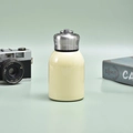 Mini cream yellow vacuum flask with sleek metal lid and handle on green background - 300ml (316 Base) / Beige