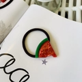 Detailed macro view of an acrylic watermelon hair tie with embedded red rhinestones - Rhinestone Watermelon - Hair Tie