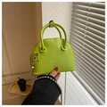 Detalle del bolso de concha verde neón con textura granulada y cadena de bolas de plata - Verde