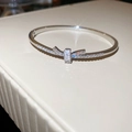 Détail d'un bracelet nœud argenté avec micro-pavé de zircons sur support en cuir blanc - Forme de nœud papillon / Argent