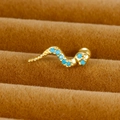 Vue macro d'une boucle d'oreille serpent dorée avec pierres bleues en boîte de velours - Serpent / Or / Bleu Ciel