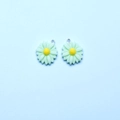Macro view of two light green resin daisy flower charms with yellow centers and silver loops - Light Green