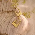 Pendientes geométricos de acero inoxidable en oro de 18K sobre fondo de madera - Hebilla geométrica en forma de U (EH281)