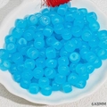 Macro view of blue translucent 6x8mm barrel beads inside a white ceramic bowl - Blue