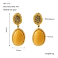 Détail de boucles d'oreilles géométriques en acier doré de 33mm avec résine et strass - Doré