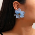 Elegant blue acrylic flower earrings with gold center bead on model ear - Sky Blue