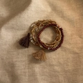 Detail of bohemian multilayered beaded bracelets with colorful tassels on linen - Bracelet-Brown