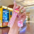 Detail of pink unicorn wristband and acrylic candy pendant on a gold keychain - Luminous Donut Round Candy