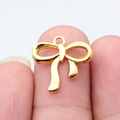 DIY gold metal bow pendant with small ring detail shown between fingertips for scale - Bright Gold