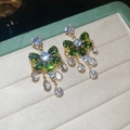 Vista macro di orecchini a fiocco verde con pietre bianche a goccia in una scatola - Verde (925 Sterling Silver Earring Post)