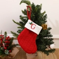 Red knit Christmas stocking with white cuff and embroidered letter G on a festive tree - Letter G