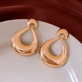 Pendientes dorados en forma de gota sobre plato de cerámica blanca y terciopelo rojo - Dorado