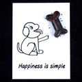 Red and black spotted natural stone dog bone on a simple creative healing card - Sesame Jasper