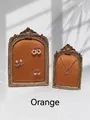 Close-up of vintage gold carved jewelry frames with orange velvet lining for display - Orange