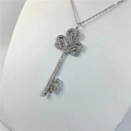 Silver iris key necklace with sparkling crystals displayed on a white jewelry stand - Platinum Fleur-de-lis Key