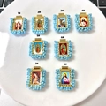 Detailed set of 8 gold religious pendants with light blue beaded borders on white tray - Lake Blue