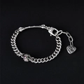 Hip-Hop-Silberarmband mit Totenkopf-Elementen und einem Herzanhänger auf dunklem Grund - Totenkopf Knochen Herz