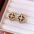Gros plan de boucles d'oreilles vintage croix dorée avec zircons et émail noir - Tige en Argent Croix Dorée
