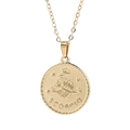 Close-up of golden round Scorpio pendant with engraved zodiac symbol and lettering - Scorpio