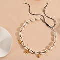 Detailed shot of white shell beaded necklace with golden fish and turtle charms - Black Rope Fish Necklace