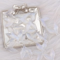 Close-up of glittery acrylic mermaid tail pendants on a soft white plush background - Luminous Glitter Fishtail White