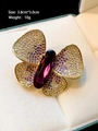 Macro-opname vlinderbroche met paarse zirkonen en geslepen edelsteen in een sieradendoosje - Gouden Paarse Vlinder (N045)