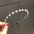 Elegante cerchietto vintage con perle bianche su filo di metallo nero nella mano - Perla Di Bambù Argento