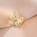 Elegante goldene Schleifenbrosche mit funkelnden Kristallen auf edlem Seidenhintergrund - Schleife Stil (XX0011)