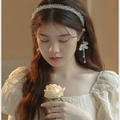 Elegant crystal beaded headband on model with soft floral background and warm tones - White