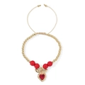 Detalle de cuentas de oro de 18k y colgante de corazón rojo en pulsera trenzada caqui - Estilo de corazón con alas