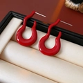 Dettaglio di orecchini a onde rosse su raso bianco in una confezione regalo di lusso - Perno per orecchini in argento - Rosso