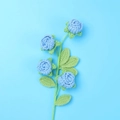 Handmade crochet rose bouquet with four blue flowers and green leaves on blue background - Finished Bubble Rose (4 Heads Blue)