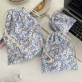 Detailed set of three floral drawstring storage bags in different sizes on a desk - Light Purple Floral