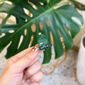 Detailed macro view of a glittery green Christmas tree brooch with star detail - Christmas Tree
