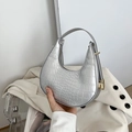 Borsa hobo argento con stampa coccodrillo e zip dorata su una giacca beige chic - Argento