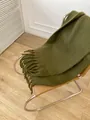 Thick dark green mohair scarf with tassels draped on a modern leather chair - Matcha Green