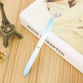 Stylo bille dégradé bleu avec cristal en forme de cœur posé sur un livre blanc - 1.0mm / Dégradé
