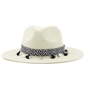 Détail d'un chapeau de paille beige avec ruban à pompons et breloques de pièces - Blanc Lait