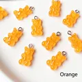 Close-up of translucent orange resin gummy bear pendant with a metal ring for DIY jewelry - Orange