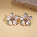 Dettaglio degli orecchini a fiore in smalto bianco con accenti di pietre turchesi - Orecchini con perno in argento / Oro