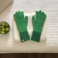 Detalle de guantes de punto bicolor verde con acabado de lana texturizada sobre tela - Verde