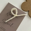 Dettaglio di un fermaglio per capelli color crema perlato con design a spirale - Pinza in Lega a Croce 13CM