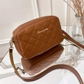 Sac bandoulière marron matelassé avec détails dorés présenté dans un décor minimaliste - Marron