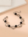 Detail of silver sun charms and black beads on a stainless steel bracelet with lobster clasp - Black Bead Sun